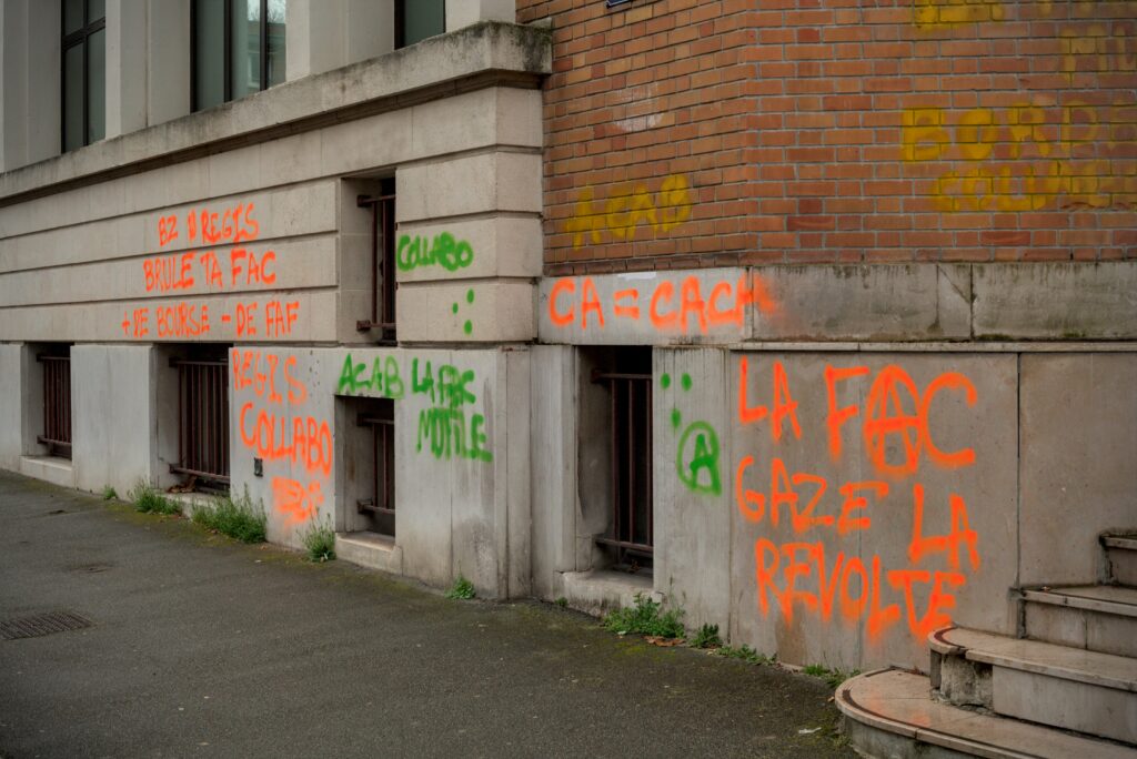 Tags : "La fac gaze la révolte", "CA = Caca", "ACAB la fac mutile" sur la façade de l'université.